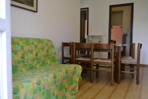 ein Wohnzimmer mit einem Sofa, einem Tisch und Stühlen in der Unterkunft Residence Conero P. T. blocco E in Marcelli