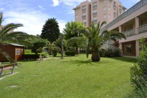 einen Rasen vor einem Gebäude mit Palmen in der Unterkunft Residence Conero P. T. blocco E in Marcelli