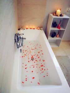 una vasca da bagno con cuori rossi sul pavimento di La Casa del Sole a Cinisi