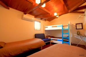 a bedroom with two beds and a bunk bed at PavilionSurf&Lodge in Shishikui
