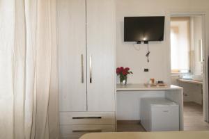 a white cabinet with a vase of flowers in a room at Civico 1 in San Mauro Cilento
