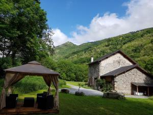 un gazebo sull'erba di fronte a un edificio di Gite la Fargue de Cabre a Vicdessos