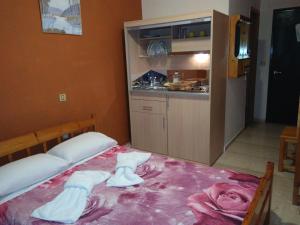 1 dormitorio con 1 cama con toallas en Astir Rooms, en Póros