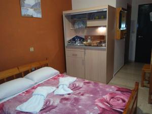 a bedroom with a bed with towels on it at Astir Rooms in Póros Kefalonias +40 photos