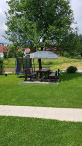 a picnic table and a bench in a park at Guest House Adrijana in Seliste Dreznicko