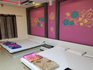 two beds in a room with purple walls at Hotel Shri Radhe Krishna in Godarpura +21 photos
