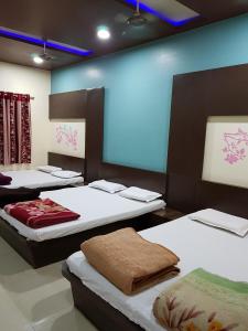 a room with four beds and a blue light at Hotel Shri Radhe Krishna in Godarpura