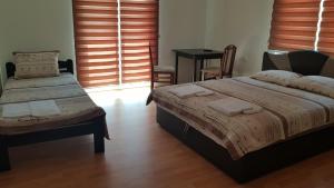 sypialnia z dwoma łóżkami, stołem i oknem w obiekcie Sunrise Hotel & Camping w mieście Struga