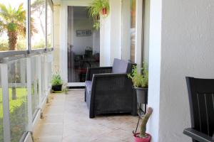 a porch with chairs and potted plants on it at Playa Esquirol in Cambrils