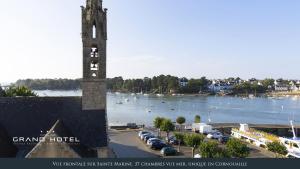 a clock tower with a view of a body of water at Grand Hôtel Bénodet Abbatiale Riviera Bretonne in Bénodet