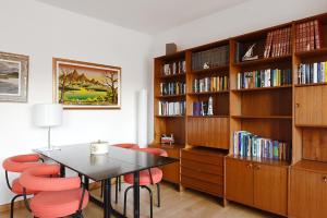 una sala da pranzo con tavolo, sedie e librerie di La Casa nel Golfo dei Poeti a San Terenzo