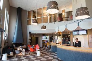 a view of the lobby of a restaurant with red chairs at Ibis Château-Thierry in Essômes-sur-Marne
