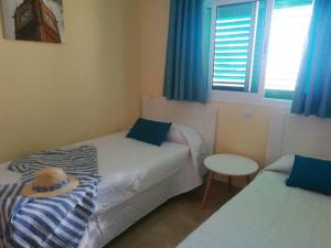 プラヤ・デル・イングレスにあるLas Olas Marのベッドルーム1室(ベッド2台、ベッドに帽子付)