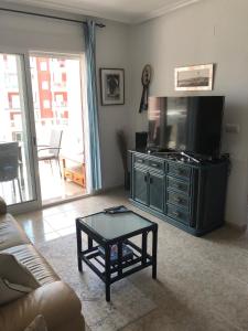 a living room with a flat screen tv and a coffee table at La Manga Apartment Capri in La Manga del Mar Menor