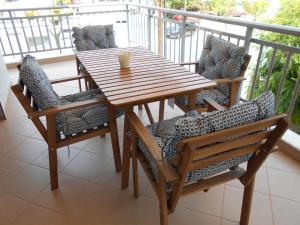 un tavolo in legno e sedie sul balcone. di Sophies Apartments Ormos a Ormos Panagias