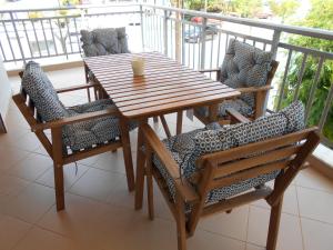 a wooden table and chairs on a balcony at Sophies Apartments Ormos in Ormos Panagias
