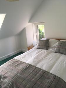 a bedroom with a bed and a window at Whisky Cottage in Inverness