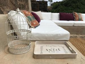 a bird cage sitting on a table next to a couch at Dammuso Sant'Anna in Pantelleria