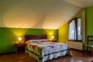 a bedroom with green walls and a bed with two lamps at Hotel Rincón de Antón in Abanillas