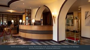 ベノデにあるGrand Hôtel Bénodet Abbatiale Riviera Bretonneのホテルのロビーにはバーとカートがあります。