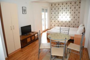 Habitación pequeña con cama, mesa y sillas en ASP Apartments, en Ohrid