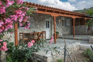 a stone house with a table and chairs at Acrocorinth Apartments in Kórinthos
