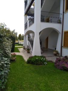 トルトリにあるAppartamenti Demurtasの階段と花の庭のある白い建物