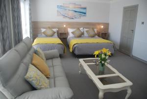 un soggiorno con due letti e un divano di Tuskar House by the Sea a Rosslare
