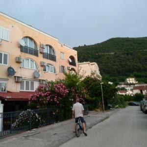 un hombre montando una bicicleta por una calle en Sunčani apartman 2-Vila Amfora, en Budva