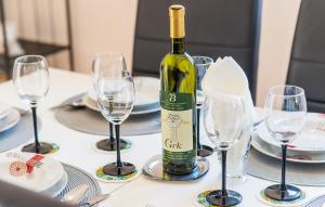 una botella de vino sentada en una mesa con copas en Apartment & Rooms Maždin, en Banići