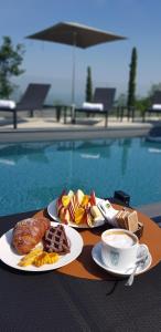 a table with two plates of food and a cup of coffee at La Ribezza Boutique Hotel in Monforte dʼAlba