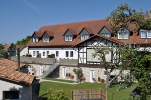 ein großes weißes und schwarzes Haus mit einem Hof in der Unterkunft Hotel Zum Stern in Rauischholzhausen