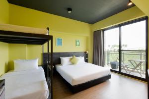 2 camas en una habitación con paredes amarillas y balcón en Mo en Houli