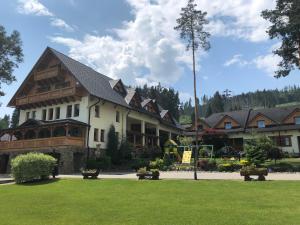 ein großes Gebäude mit grünem Rasen davor in der Unterkunft Slanický Dvor in Námestovo