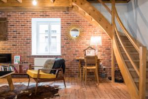 a room with a brick wall and a table and chairs at Gite le Pot de Vin in Lancié