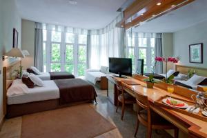 a hotel room with a bed and a desk at VP Jardín de Tres Cantos in Tres Cantos