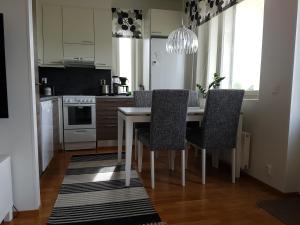 ロヴァニエミにあるAdorable Arctic Apartment with saunaのキッチン(ダイニングルームテーブル、椅子付)