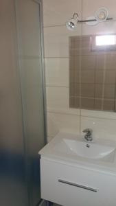 a bathroom with a white sink and a mirror at Apartament Małgosia in Swarzewo