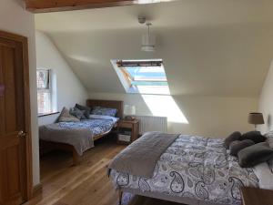 a attic bedroom with two beds and a window at Ocean View B&B in Dingle