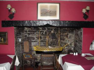 a room with a fireplace and a table with a vase of flowers at Townstal Farmhouse in Dartmouth