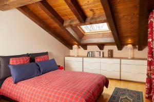 a bedroom with a bed with a red checked blanket at La Terrasse d'Ozein in Ozein