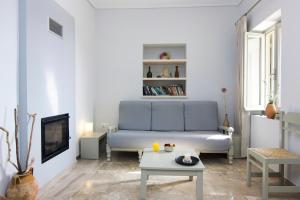 a living room with a blue couch and a table at Madena Apartments in Stoupa