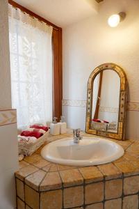 a bathroom with a sink and a mirror at La Terrasse d'Ozein in Ozein