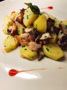 un plato blanco de comida con patatas y carne en Hotel Montiruju, en Santa María