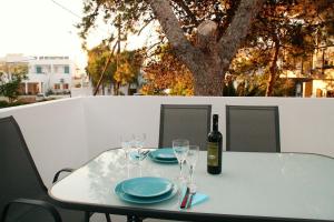 a table with a bottle of wine and glasses on it at Orama Suites II in Kato Daratso