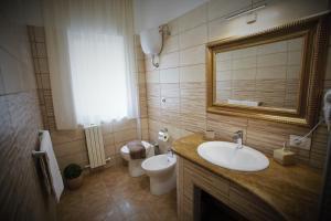 łazienka z umywalką, toaletą i lustrem w obiekcie Central Apartments w mieście Crotone +37 zdjęć