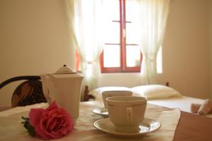 a table with a tea pot and a rose on it at La Casa di Nonna in Qeparo