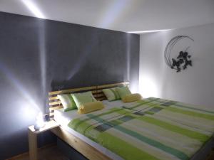 a bedroom with a bed with green and white sheets at Ferienwohnung Heimsheim in Heimsheim