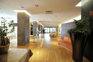 a living room with a couch and some plants at Hotel Major in Ronchi dei Legionari