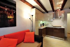 salon z czerwoną kanapą i kuchnią w obiekcie Palace La Vida Apartments w Wenecji